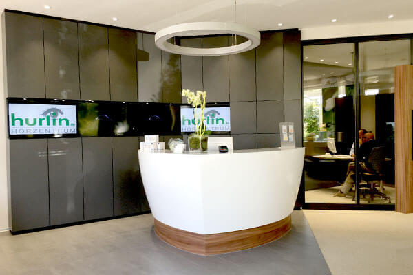 Moderner Empfangsbereich im Hörzentrum mit elegantem Tresen und stilvoller Dekoration.
