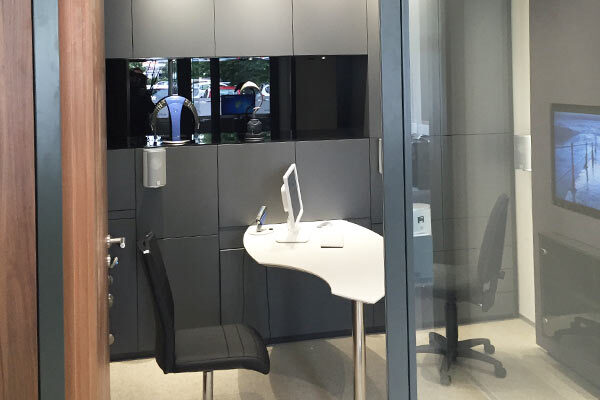 Modernes Beratungszimmer mit Schreibtisch, Stuhl und Monitor in einem Bankgebäude.